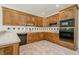 Functional kitchen boasts wood cabinetry, a black dishwasher and complementary tile backsplash at 2814 Tanner Lake Nw Trl, Marietta, GA 30064