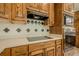 A close-up of a kitchen with wood cabinets, white counters, and tile backsplash at 2814 Tanner Lake Nw Trl, Marietta, GA 30064