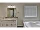 Well-lit bathroom with a vanity, granite countertop, and a large garden tub at 3573 Plantation Pl, Loganville, GA 30052