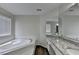 Elegant bathroom featuring a soaking tub, granite countertop, and wood-look flooring at 3573 Plantation Pl, Loganville, GA 30052