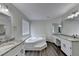 Luxurious bathroom with a soaking tub, double vanities, granite countertops, and wood floors at 3573 Plantation Pl, Loganville, GA 30052