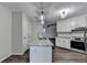 Open kitchen with granite countertops, stainless steel appliances, and an island flowing into the living room at 3573 Plantation Pl, Loganville, GA 30052