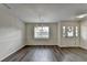 Open-concept living space with gray flooring, wainscoting detail, and plenty of natural light at 3573 Plantation Pl, Loganville, GA 30052