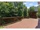 Wooden back deck surrounded by trees offers a private outdoor retreat at 7090 River Island Cir, Buford, GA 30518