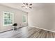 This bedroom features laminate floors, neutral paint, and two windows for natural light at 7090 River Island Cir, Buford, GA 30518