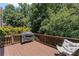 Relaxing deck with a grill and comfortable chair, perfect for enjoying the outdoor view at 7090 River Island Cir, Buford, GA 30518
