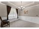 Elegant dining room with tray ceiling, wainscoting, chandelier, and natural light at 7090 River Island Cir, Buford, GA 30518