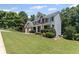 Charming two-story home with lush green lawn, accented by mature trees and neat shrubbery at 7090 River Island Cir, Buford, GA 30518