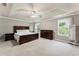Spacious main bedroom features a decorative ceiling, carpet, and multiple windows for natural light at 7090 River Island Cir, Buford, GA 30518