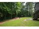 Lush backyard featuring mature trees, lawn and an outdoor fire pit area at 177 Rustin Dr, Dallas, GA 30157