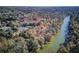 Areal view of green river among colorful fall trees with neighborhood amenities including tennis courts at 295 Sagamore Nw Cv, Sugar Hill, GA 30518