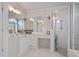 Bright white bathroom featuring a double mirror vanity and glass-enclosed shower at 295 Sagamore Nw Cv, Sugar Hill, GA 30518