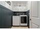 This laundry room has modern front loading machines and storage cabinets above at 295 Sagamore Nw Cv, Sugar Hill, GA 30518