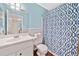 Cozy bathroom with a patterned shower curtain, white vanity, and natural light at 5055 Southland Dr, Woodstock, GA 30188