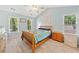 Bright bedroom with a large window and natural light, featuring a ceiling fan and a comfortable bed at 5055 Southland Dr, Woodstock, GA 30188