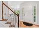 Bright foyer with hardwood floors, stairs with white risers, and natural light from the sidelight windows at 5055 Southland Dr, Woodstock, GA 30188