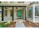 Inviting front porch with black columns, ceiling fans, and a pop of color from the bright green door at 5055 Southland Dr, Woodstock, GA 30188