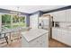 The kitchen has white cabinets, an island, stainless appliances, and lots of natural light at 5055 Southland Dr, Woodstock, GA 30188
