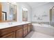 Bright primary bath featuring dual vanities, soaking tub, and separate shower with mosaic tile accents at 5710 Waters Edge Trl, Roswell, GA 30075