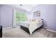 Bedroom with lots of natural light, a black bed frame, and calm lavender-painted walls at 5710 Waters Edge Trl, Roswell, GA 30075