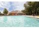 Community pool with brick clubhouse surrounded by trees and lounge chairs for relaxation at 5710 Waters Edge Trl, Roswell, GA 30075