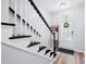 Inviting entryway with wood floors, black and white staircase, and decorative front door with wreath at 5710 Waters Edge Trl, Roswell, GA 30075