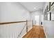 Upstairs hallway with wood floors and white railing, leading to bedrooms and laundry area at 5710 Waters Edge Trl, Roswell, GA 30075