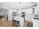 Well-lit kitchen featuring white cabinets, a breakfast bar, and stainless steel appliances at 5710 Waters Edge Trl, Roswell, GA 30075