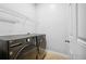 Practical laundry room equipped with modern washer and dryer units and storage shelving at 5710 Waters Edge Trl, Roswell, GA 30075