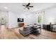 Inviting living room featuring hardwood floors, a comfortable gray sectional sofa, and a large TV at 5710 Waters Edge Trl, Roswell, GA 30075