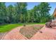 Lush backyard with a brick patio, grassy area, and mature trees, ideal for outdoor enjoyment at 965 Grimes Bridge Rd, Roswell, GA 30075