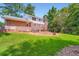 Expansive backyard featuring lush greenery, a brick patio, and mature trees, perfect for relaxation at 965 Grimes Bridge Rd, Roswell, GA 30075