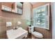 Traditional bathroom with a white sink, a toilet, and a large window providing natural light at 965 Grimes Bridge Rd, Roswell, GA 30075