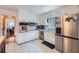 Charming kitchen featuring white cabinetry, stainless steel appliances, and bright tile flooring at 965 Grimes Bridge Rd, Roswell, GA 30075