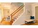 Elegant foyer with hardwood floors, white staircase, and a cozy bench at 3873 Rains Ne Ct, Brookhaven, GA 30319