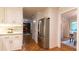 White kitchen with stainless steel refrigerator and parquet floors looking into living spaces at 3873 Rains Ne Ct, Brookhaven, GA 30319