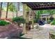 Serene backyard with a stone patio, outdoor fireplace, and a charming gazebo at 5105 Riverthur Pl, Duluth, GA 30096
