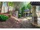 Lush backyard featuring manicured landscaping, a stone retaining wall, and a peaceful gazebo at 5105 Riverthur Pl, Duluth, GA 30096