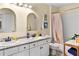 Well-lit bathroom with a double sink vanity, decorative mirrors, and patterned floors at 5105 Riverthur Pl, Duluth, GA 30096
