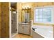 Well-lit bathroom featuring a shower, jacuzzi tub, vanity, and floral wallpaper at 5105 Riverthur Pl, Duluth, GA 30096