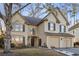Charming two-story stucco home with a two-car garage, complemented by a well-maintained front yard and mature trees at 5105 Riverthur Pl, Duluth, GA 30096