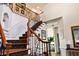 Elegant foyer with a wooden staircase featuring an intricate wrought iron railing and stylish decor at 5105 Riverthur Pl, Duluth, GA 30096
