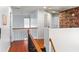 Hallway with hardwood floors, decorative railing, and stylish bookshelf-themed wallpaper at 5105 Riverthur Pl, Duluth, GA 30096