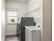 Functional laundry room featuring a washer, dryer, utility sink, and ample natural light at 5105 Riverthur Pl, Duluth, GA 30096
