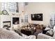 Sunlit living room featuring a fireplace, large windows, and comfortable seating arrangement at 5105 Riverthur Pl, Duluth, GA 30096