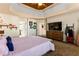 Spacious main bedroom with tray ceilings, a tv, and wall decor at 5105 Riverthur Pl, Duluth, GA 30096