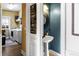 Charming powder room with a pedestal sink, decorative mirror, and view to a laundry room at 5105 Riverthur Pl, Duluth, GA 30096