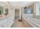 Bathroom featuring tiled floors, a soaking tub, a walk-in shower, and double vanities at 1087 Halletts Peak Pl, Lawrenceville, GA 30044