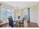 Dining room with hardwood floors, modern chandelier, and ample natural light from a window at 1087 Halletts Peak Pl, Lawrenceville, GA 30044