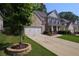 View of a two-story brick home with a two-car garage and well-maintained lawn at 1087 Halletts Peak Pl, Lawrenceville, GA 30044